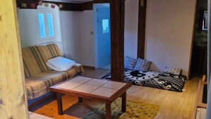 A cozy room with a wooden ceiling, a sofa, a bed, and a small table. - Cabano for rent by the sea  (Hyères)