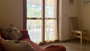 A room with a red sofa, a wooden chair, and a large window with curtains. - M397 - Marcelli, delightful three-room apartment 200m from the sea (Marcelli)