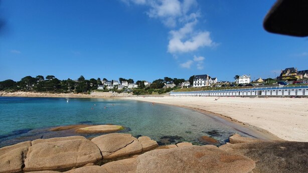 A beach with clear water, a rocky foreground, and houses in the background. - Les Méloines - Trebeurden (TREBEURDEN)