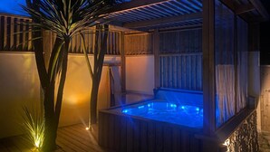 A wooden deck with a hot tub, surrounded by wooden walls and a palm tree. - Echappée Breizh - Saint Pierre Quiberon (SAINT PIERRE QUIBERON)