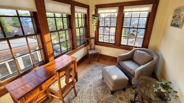 Une pièce chaleureuse avec un bureau en bois, un fauteuil confortable et un canapé.