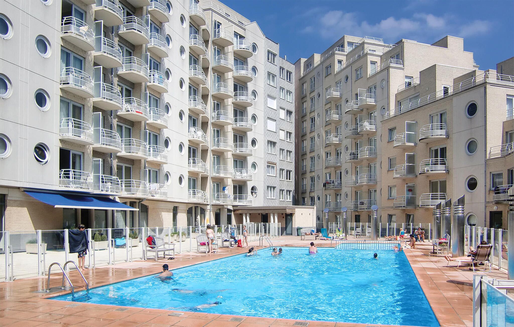 A swimming pool surrounded by multi-story residential buildings with balconies.