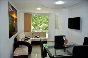Family Studio | Living area | 43-inch LED TV with satellite channels - Aparta Hotel Jardines del Caney (Cali)