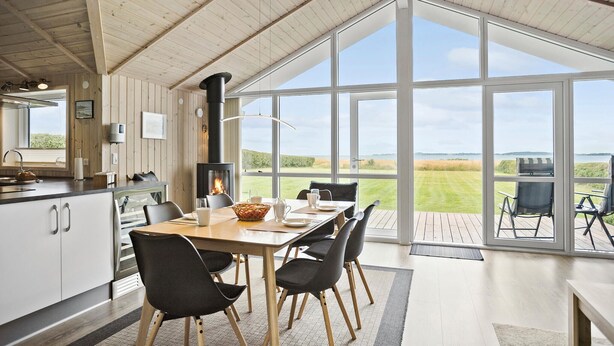 A spacious kitchen with a large dining area, a fireplace, and a view of the outdoors. - 3 bedroom awesome home in Faaborg (Faaborg)