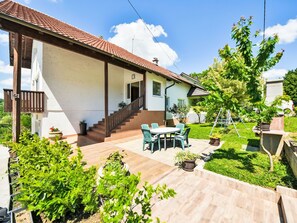 A house with a covered patio, a staircase leading to the entrance, and a garden with potted plants. - Bastaja Rastoke by Interhome (Slunj)