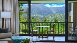 A balcony with a table and chairs, a sofa, and a view of mountains. - Hanalei Bay Resort 52012 - Newly updated, Bay views, Private walk to beach & AC! (Princeville)