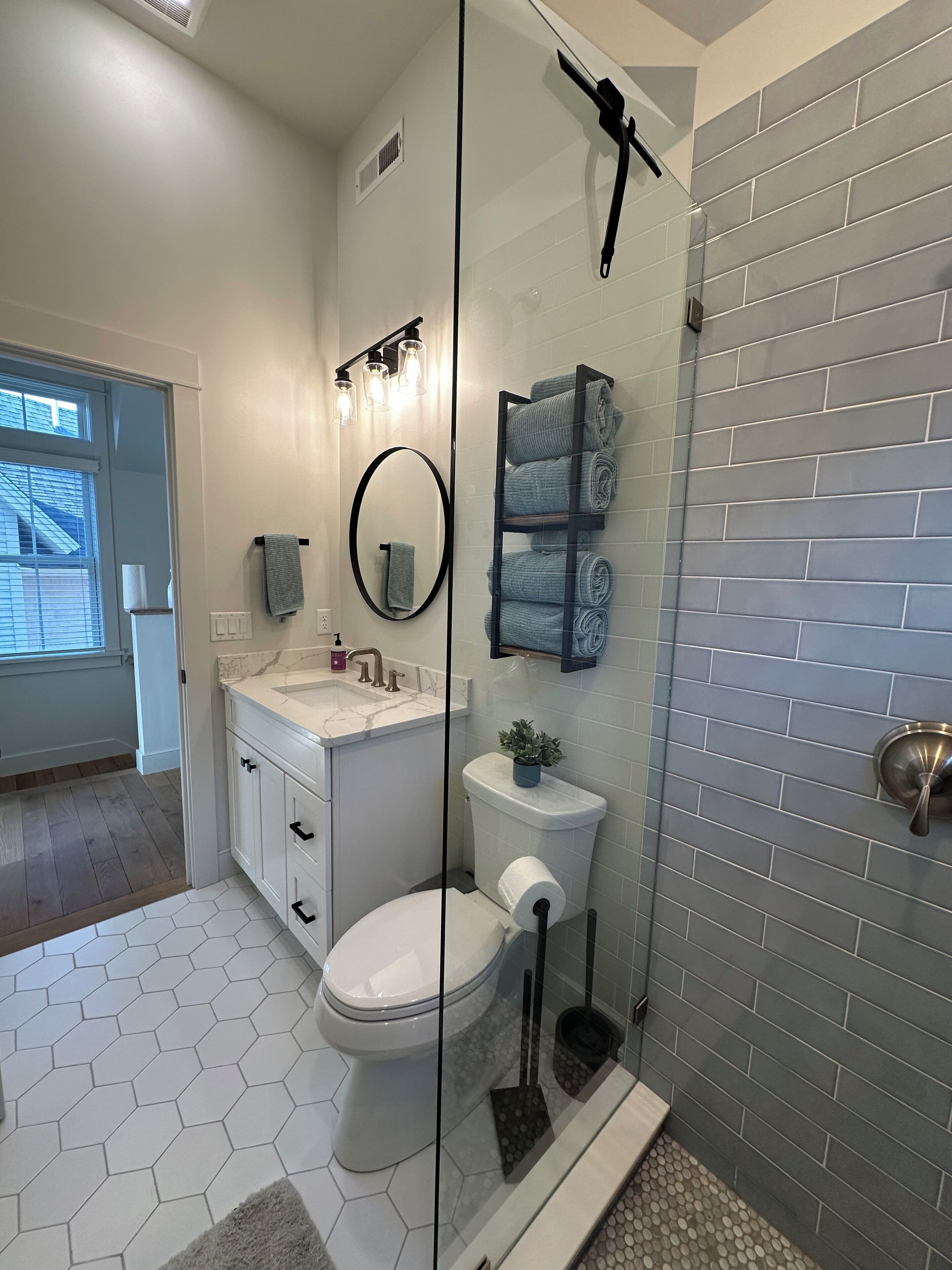 A modern bathroom with a toilet, sink, and shower area.