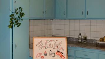 A kitchen with light blue cabinets, a whiteboard with drawings, and a hanging light fixture.
