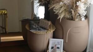 A room with a large mirror, a potted plant, a small table with a basket, and a framed picture. - El Otel Hotel (Cairo)