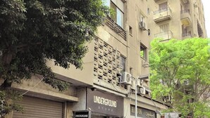 A street view with parked cars, a building with an 'Underground Store' sign, and a tree with green leaves. - El Otel Hotel (Cairo)