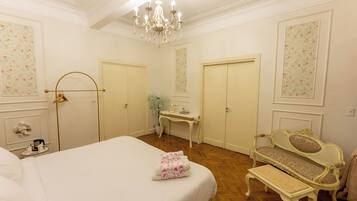 Una camera d'albergo con un letto grande, una panca, una scrivania e una sedia.