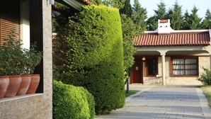 Une maison avec un toit en tuiles, une façade en briques et un jardin bien entretenu.