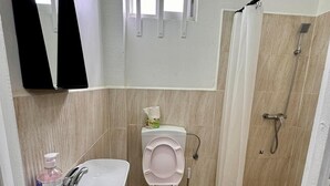 A bathroom with a sink, toilet, and shower.