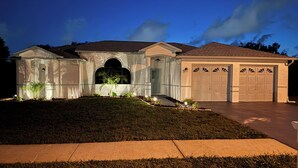 A two-story house with a garage, a covered entryway, and a landscaped front yard. - Pool and Fishing Lake Oasis (Port Richey)