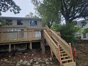 Eine Holzterrasse mit einer Treppe zu einem Haus.