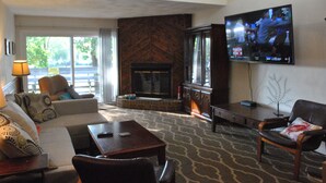 A living room with a fireplace, a television mounted on the wall, and a sofa.