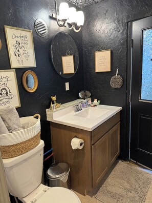 Ein Badezimmer mit Toilette, Waschbecken, Waschtisch und Dekorationselementen.