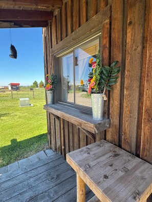 A wooden cabin with a window, a bench, and a hanging light fixture. - Little cabin. Big skies. Serious comfort and relaxation. Legendary views. (Belgrade)