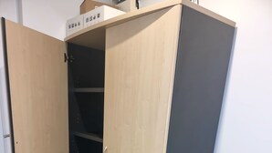 Ein Eckschrank mit Schiebetür, Holzboden und weißer Wand.
