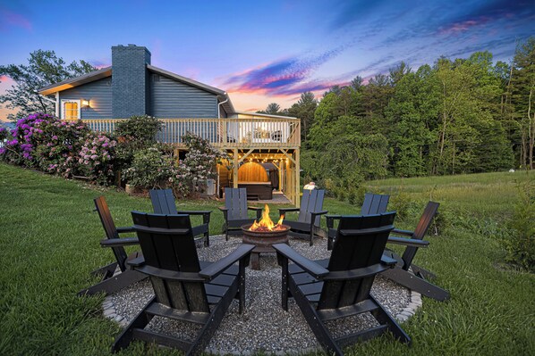 A house with a deck, a fire pit, and outdoor seating.