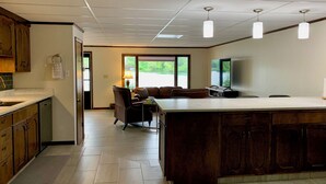 Una cocina moderna con una isla grande, armarios de madera e iluminación colgante.