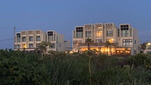 A modern building with multiple floors, large windows, and a well-lit entrance area. - Gongzonestay (Jeju City)
