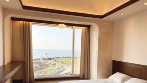 A bedroom with a large window, a bed, and a bedside table. - Gongzonestay (Jeju City)