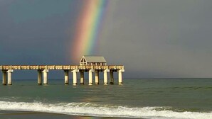 Un muelle con una casa al final, que se adentra en una masa de agua.
