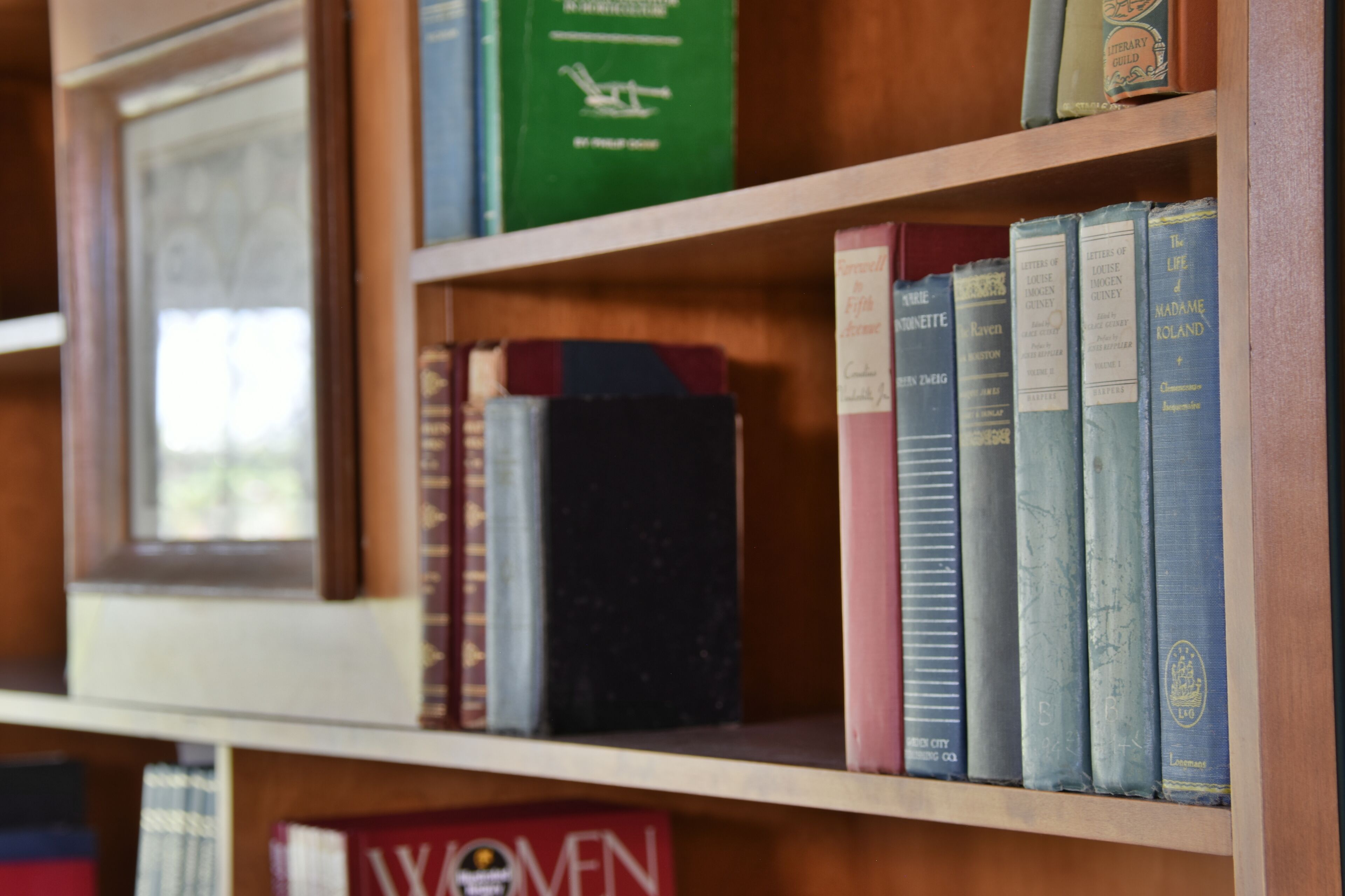 A bookshelf with various books, including titles like 'The Life of Madame Roland' and 'Letters of a Philosopher'.