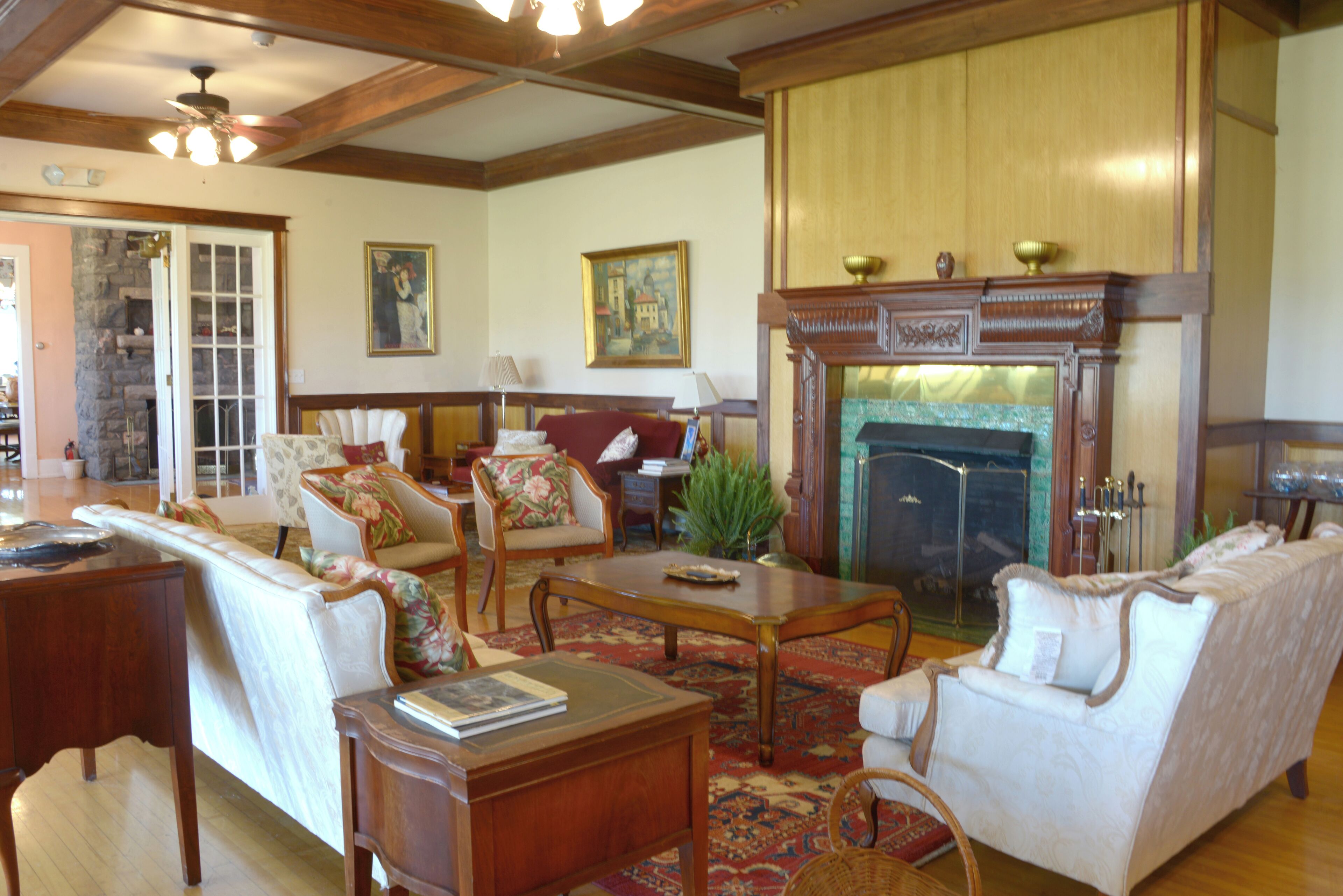 A traditional living room with a fireplace, wooden furniture, and a stone wall.