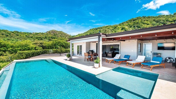 Un espace piscine extérieur moderne, aménagé avec un coin repas et des chaises longues.