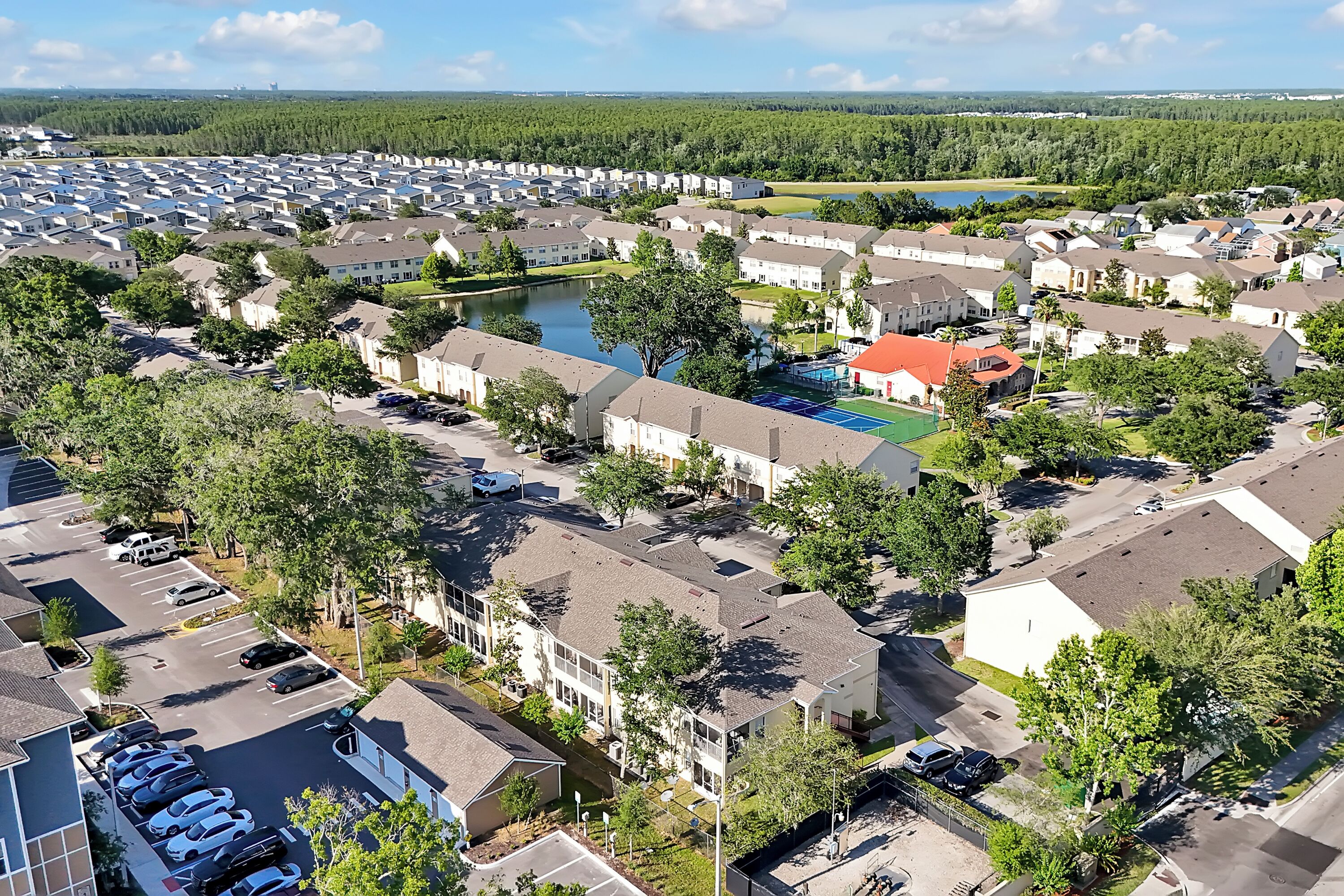 A residential area with houses, a swimming pool, and a lake.