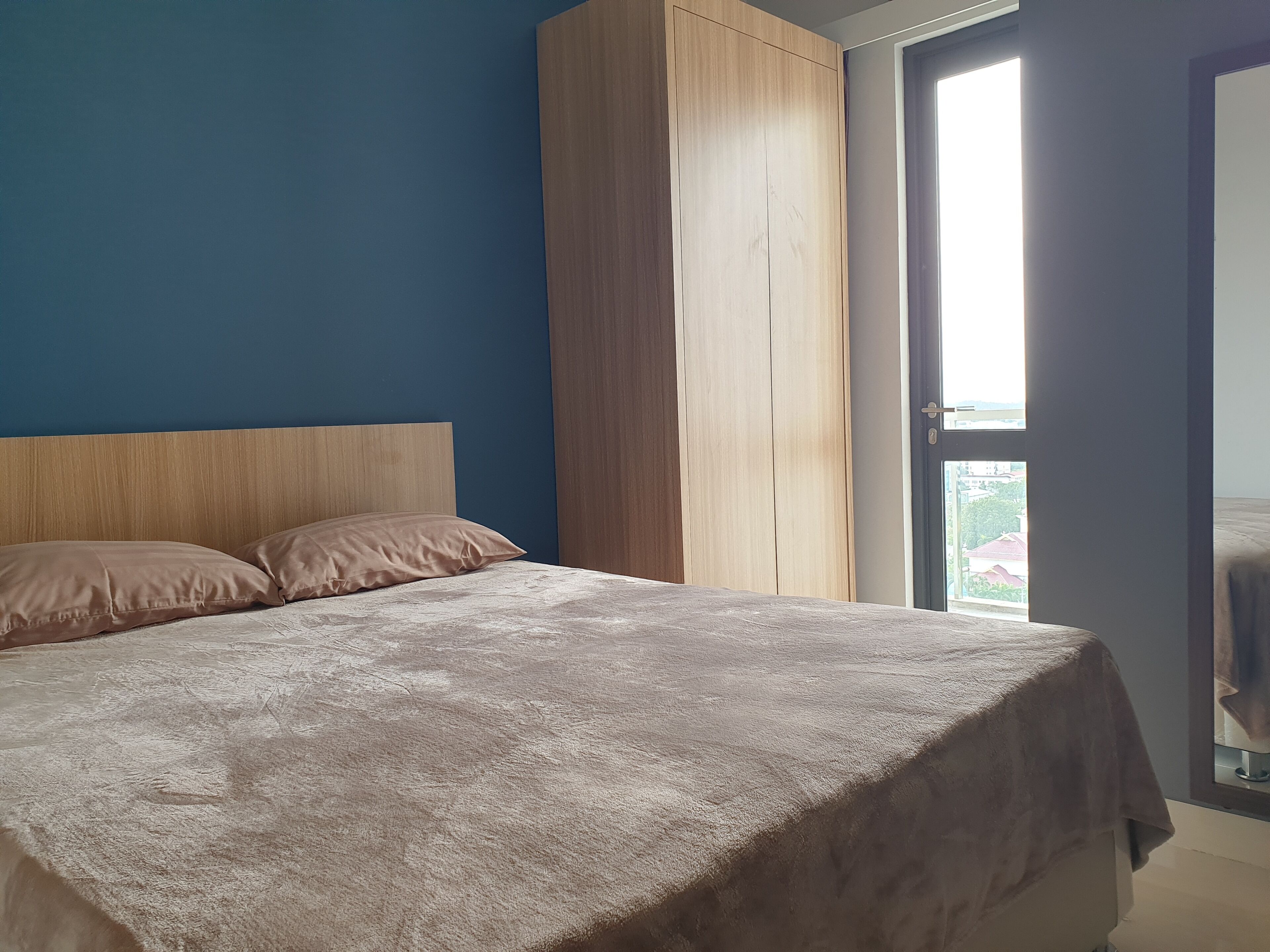Une chambre à coucher avec un lit, une armoire en bois et une fenêtre.