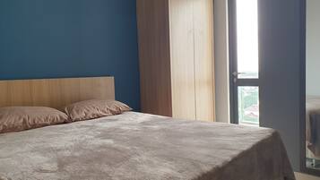 Une chambre à coucher avec un lit, une armoire en bois et une fenêtre.