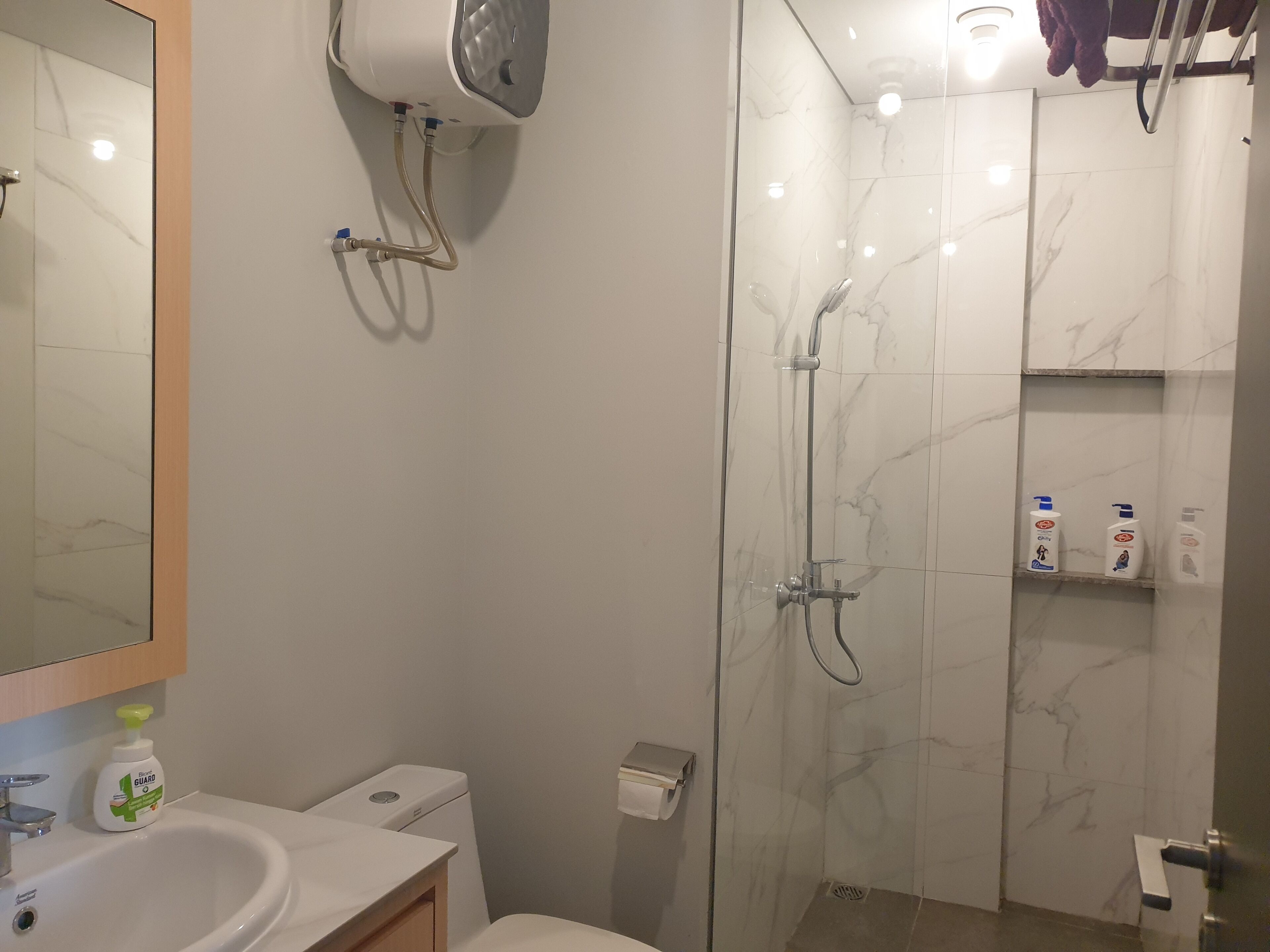 A bathroom with a toilet, sink, and shower area.