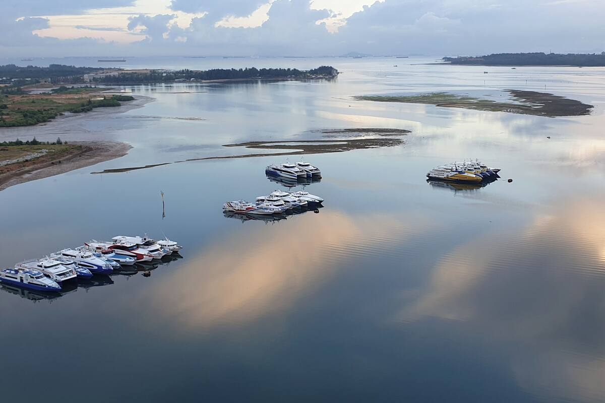 Ein ruhiger Fluss mit mehreren Booten, die am Ufer vertäut sind.