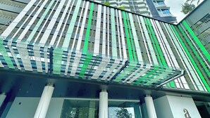 Un hôtel de grande hauteur au design moderne, doté d’une entrée imposante avec des portes en verre et d’une enseigne bien visible indiquant « Almas Suites ».