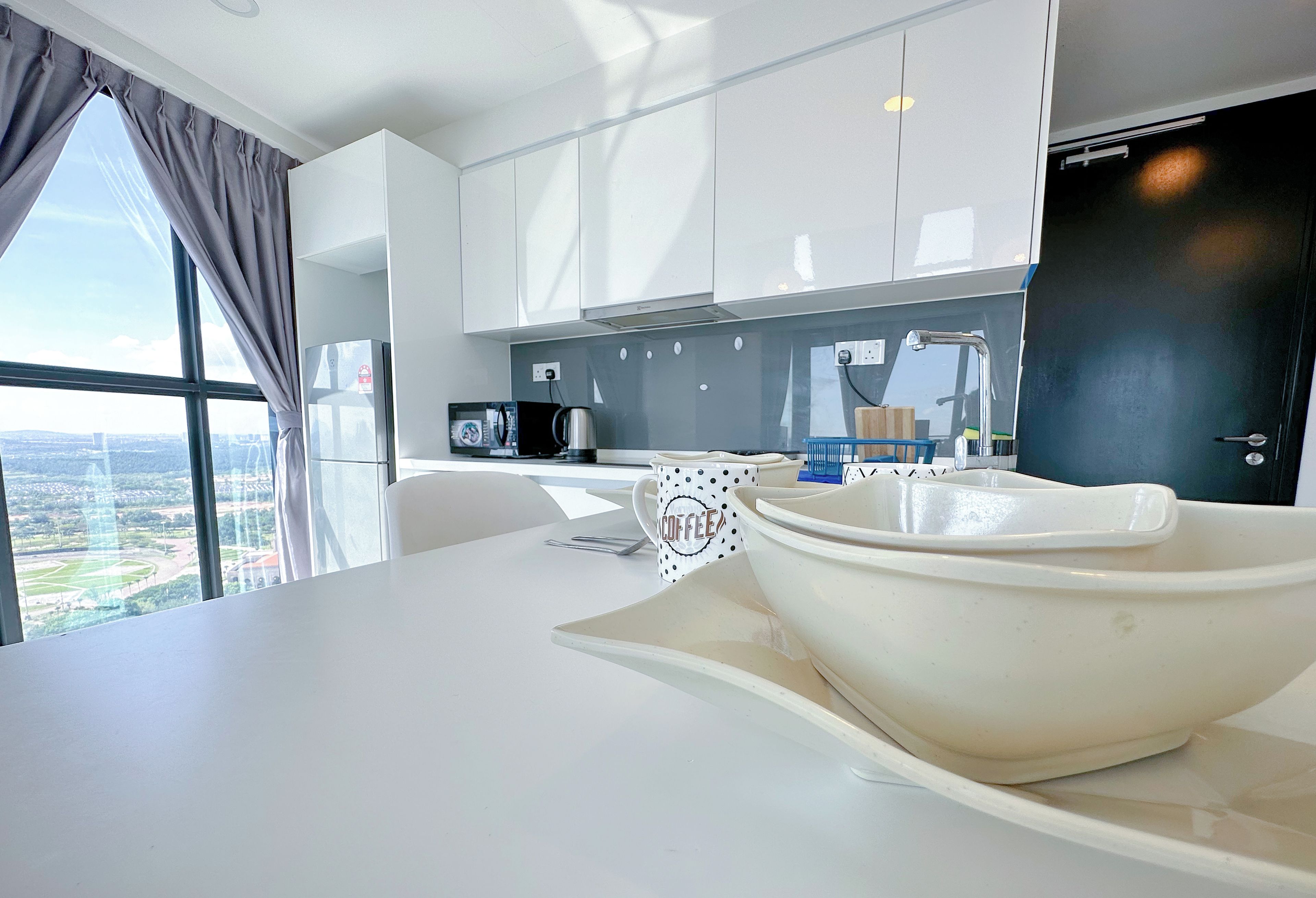 A modern kitchen with a large island, a microwave, and a coffee maker.