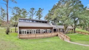 A two-story building with a wooden deck and a covered outdoor area.