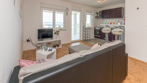 Eine moderne Wohnung mit Wohnzimmer, Küche und Balkon.