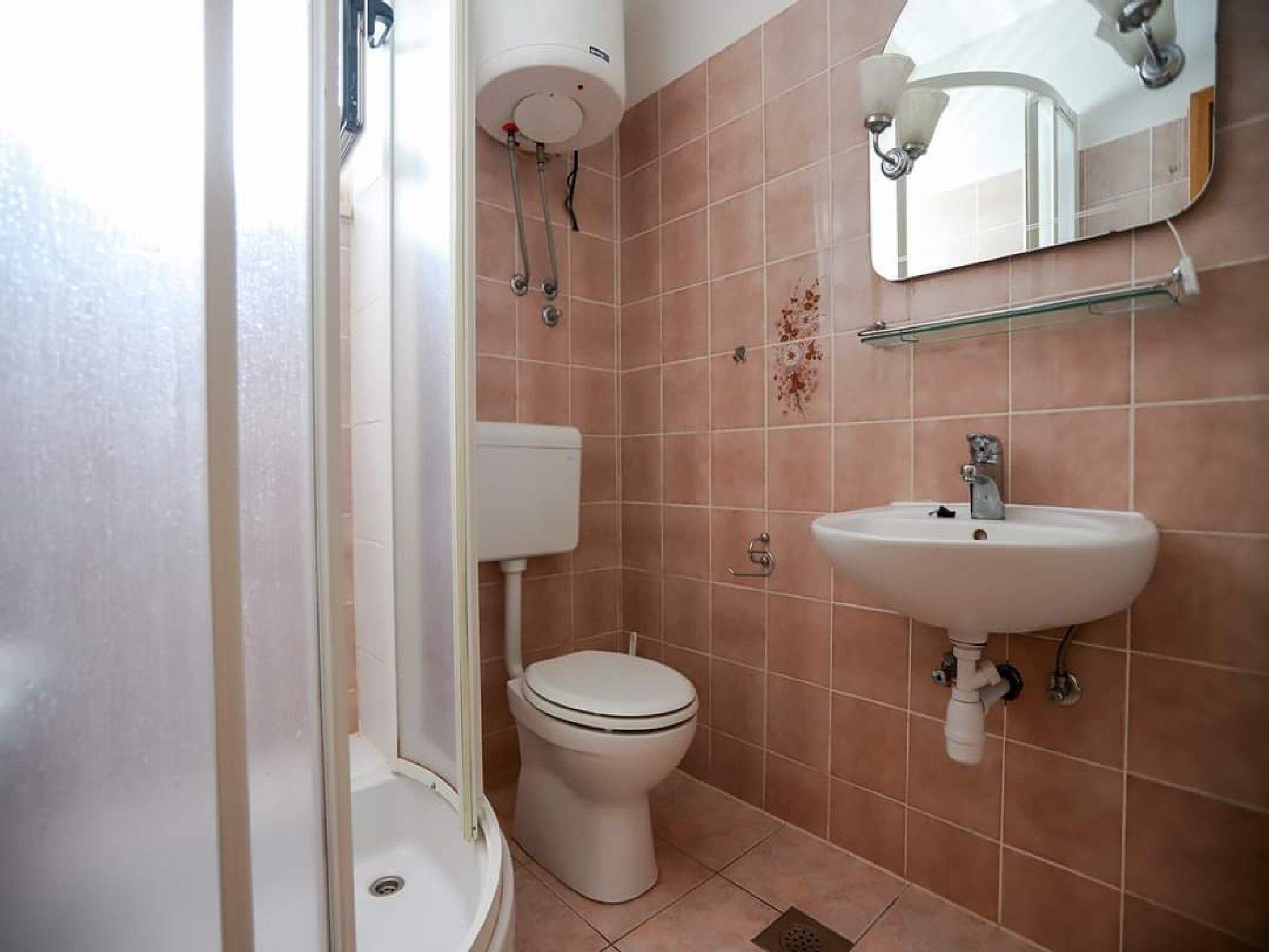 A bathroom with a toilet, sink, and shower.