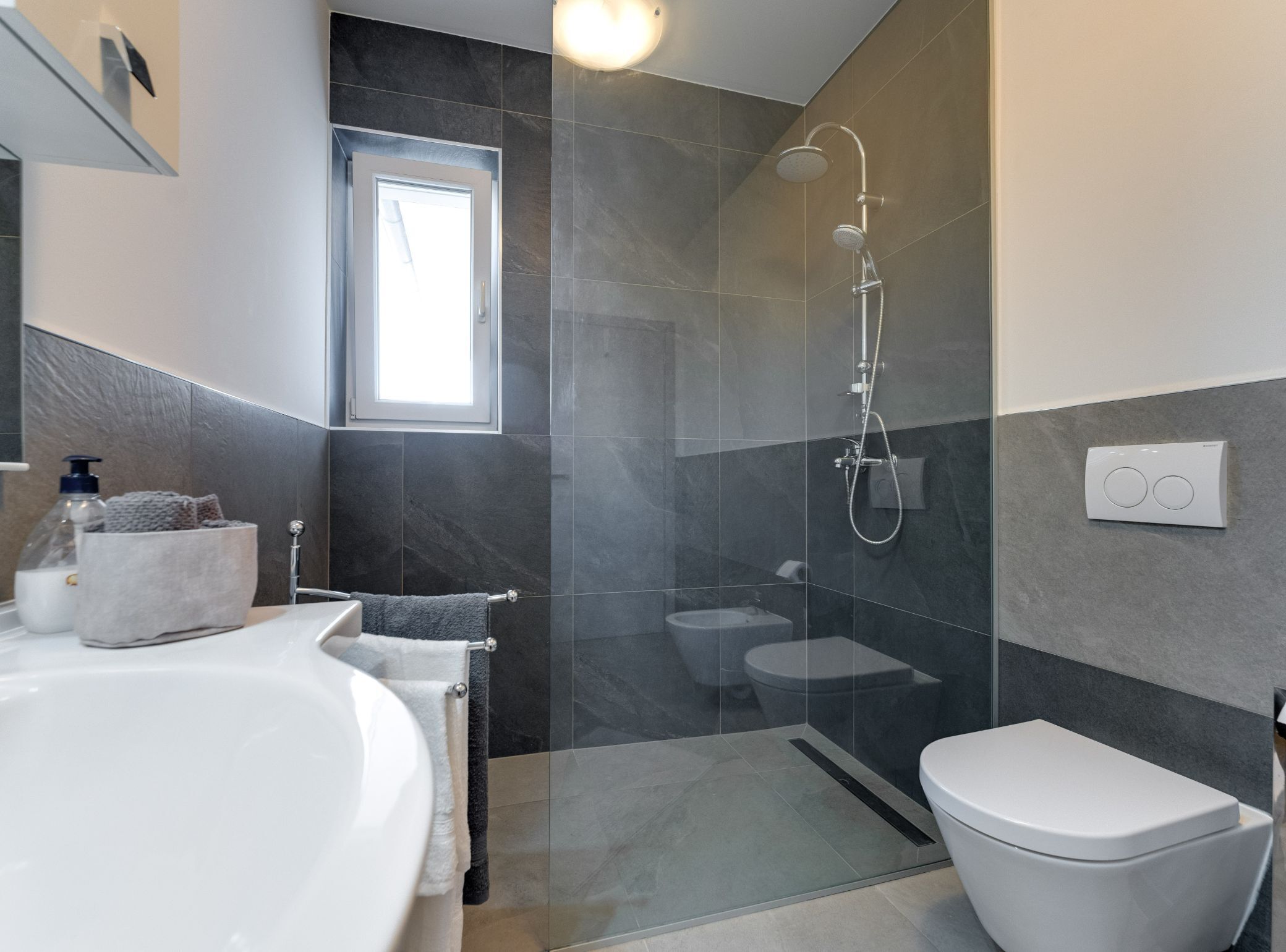 Un bagno moderno dotato di vasca, WC e doccia.