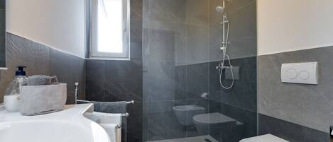 Un bagno moderno dotato di vasca, WC e doccia.