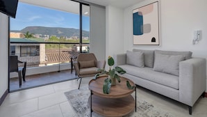 Una sala de estar moderna con un sofá, una mesa de centro y un televisor.