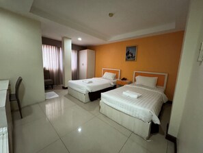 A hotel room with two beds, a desk, and a chair. - ORCHID INN  at  SKV 3 (Bangkok)