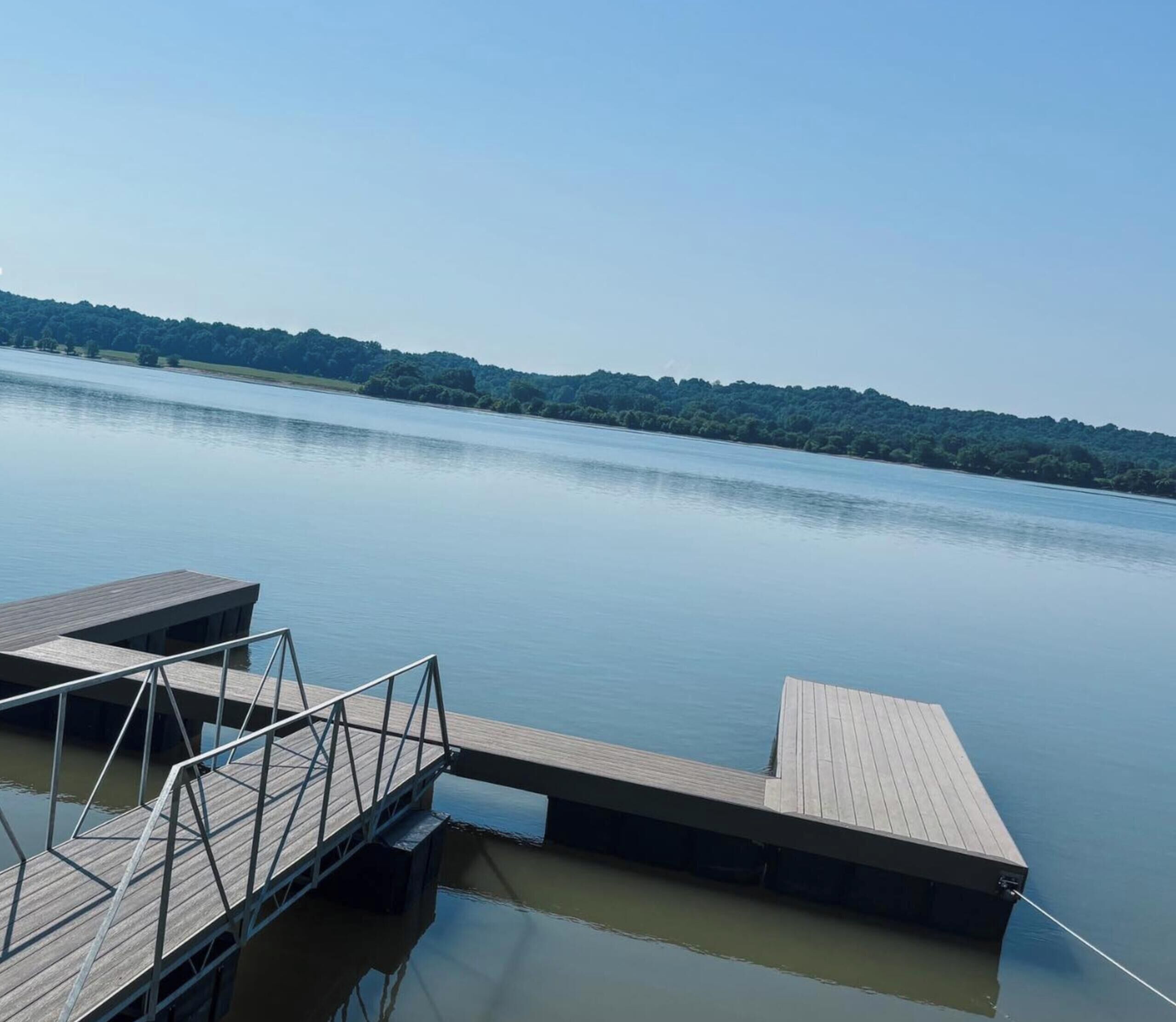 A calm lake with a wooden dock extending into the water.