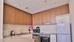 Eine moderne Küche mit Holzausstattung, Edelstahlgeräten, einer Spüle und einer Mikrowelle.