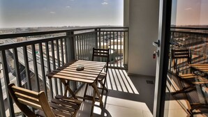 Ein Balkon mit Tisch und Stühlen, der einen Blick auf die Stadt und die Autobahn bietet.