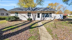 A single-story house with a front yard, a pathway leading to the front door, and a small front porch. - Modern 3BD/2BA near U of I with a large master suite! (Champaign)