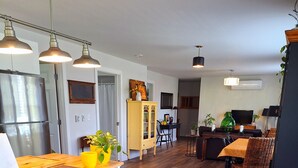 Una cocina moderna con encimera de madera, horno empotrado y comedor con mesa y sillas de madera.